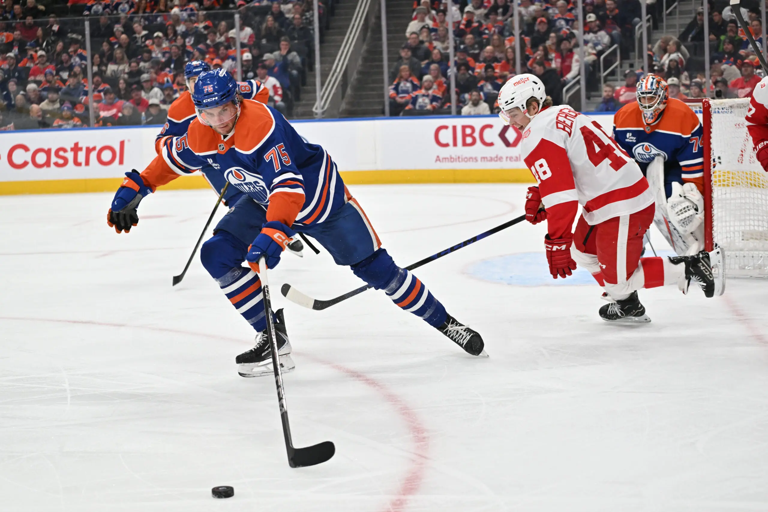 Dec 11, 2025; Edmonton, Alberta, CAN; Edmonton Oilers defenseman Alec Regula (75) chases the puck with Detroit Red Wings right winger Jonatan Berggren (48) during the second period at Rogers Place. Mandatory Credit: Walter Tychnowicz-Imagn Images